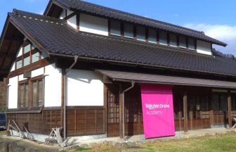 楽天ドローンアカデミーの外見。和風な建物とピンク色のバナー。まるで京都。